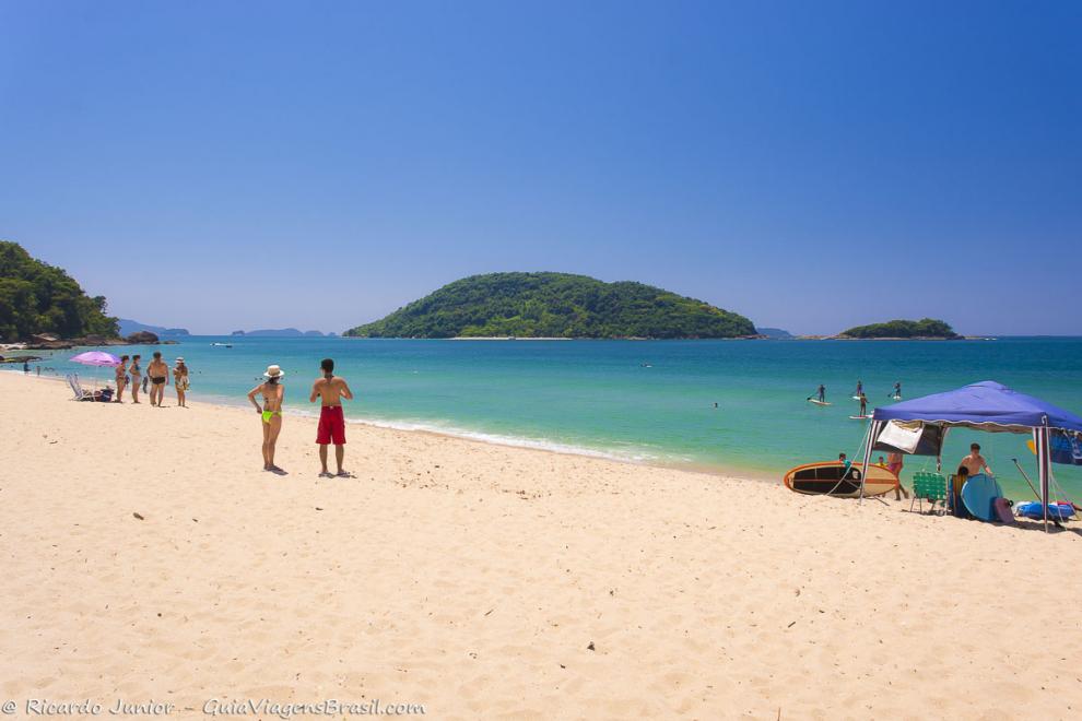 Imagem de amigos conversando nas areias da Praia de Prumirim.